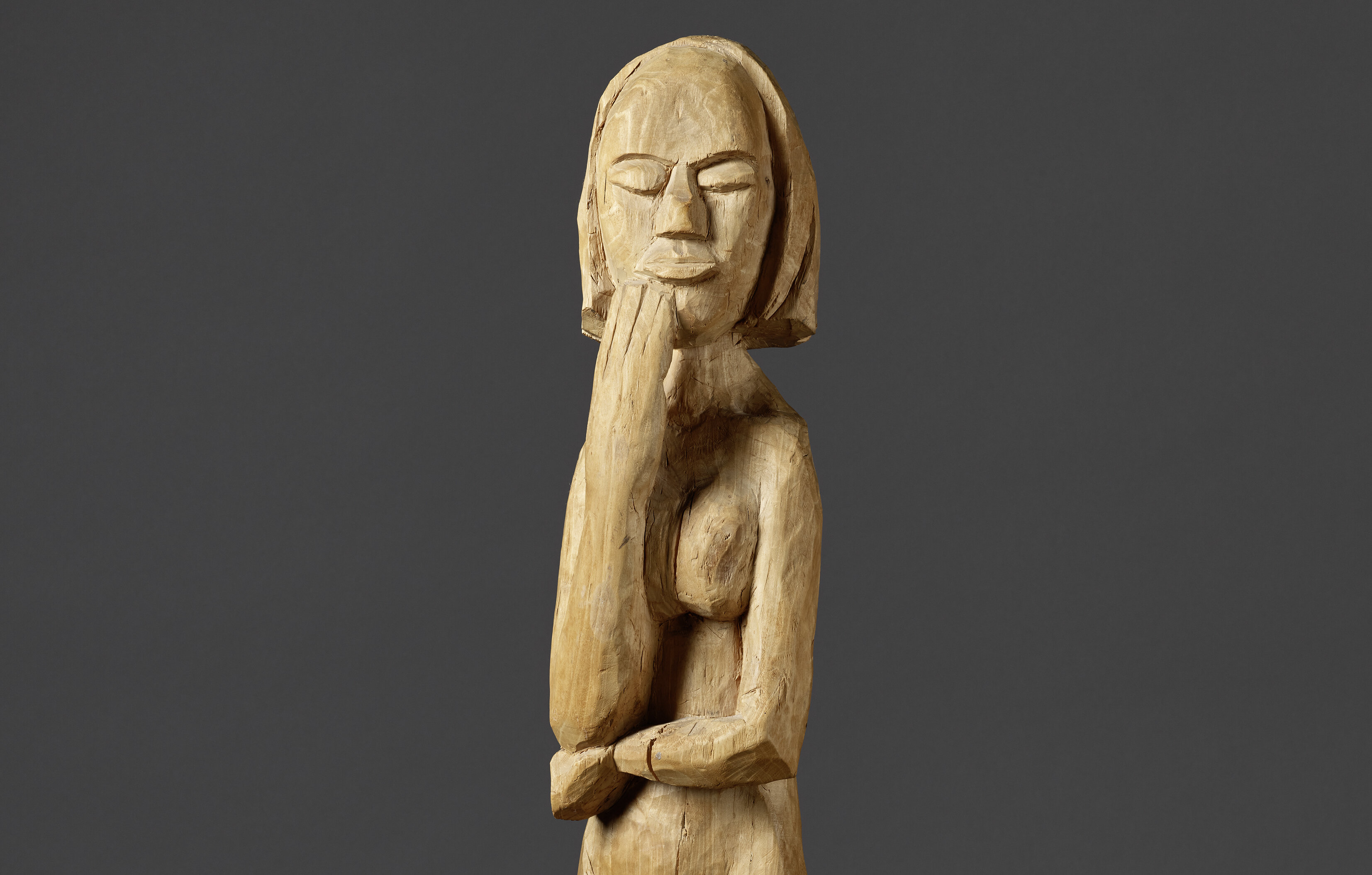 Zu sehen ist die neuangekaufte Skulptur von Erich Heckel „Die Stehende“ von 1920. Sie Figur ist aus Pappelholz und 79 x 13,5 x 17,5 Zentimeter groß und steht vor einem grauen Hintergrund.