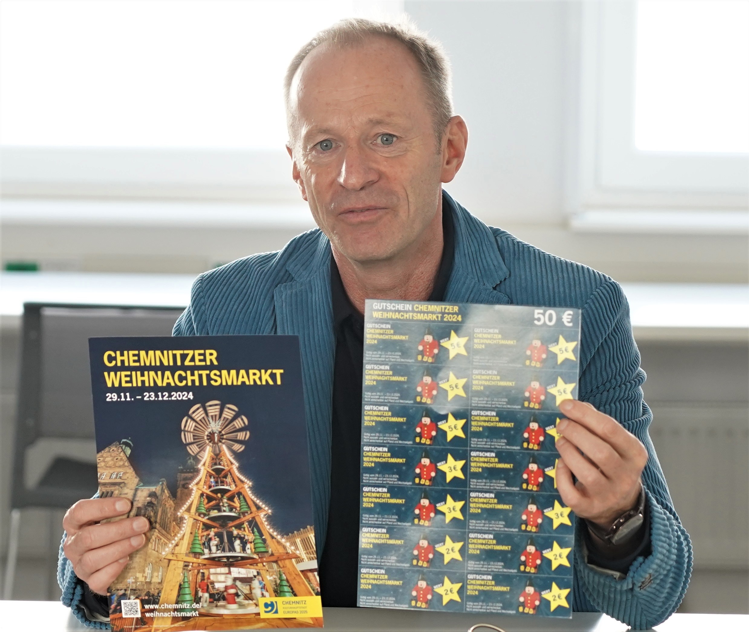 Bürgermeister Knut Kunze präsentiert die neuen Weihnachtsmarkt-Gutscheine