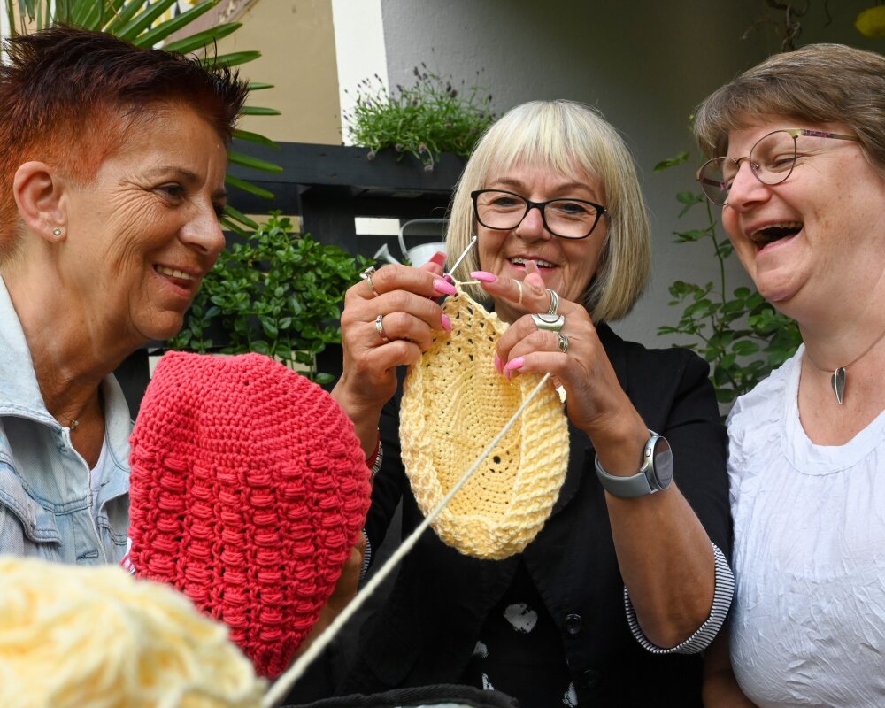 Petra Minks, Ellen Nürnberger und Grit Albrecht sind der harte Kern der Mützenladys, die ehrenamtlich unter anderem für krebskranke Menschen Kopfbedeckungen herstellen. 