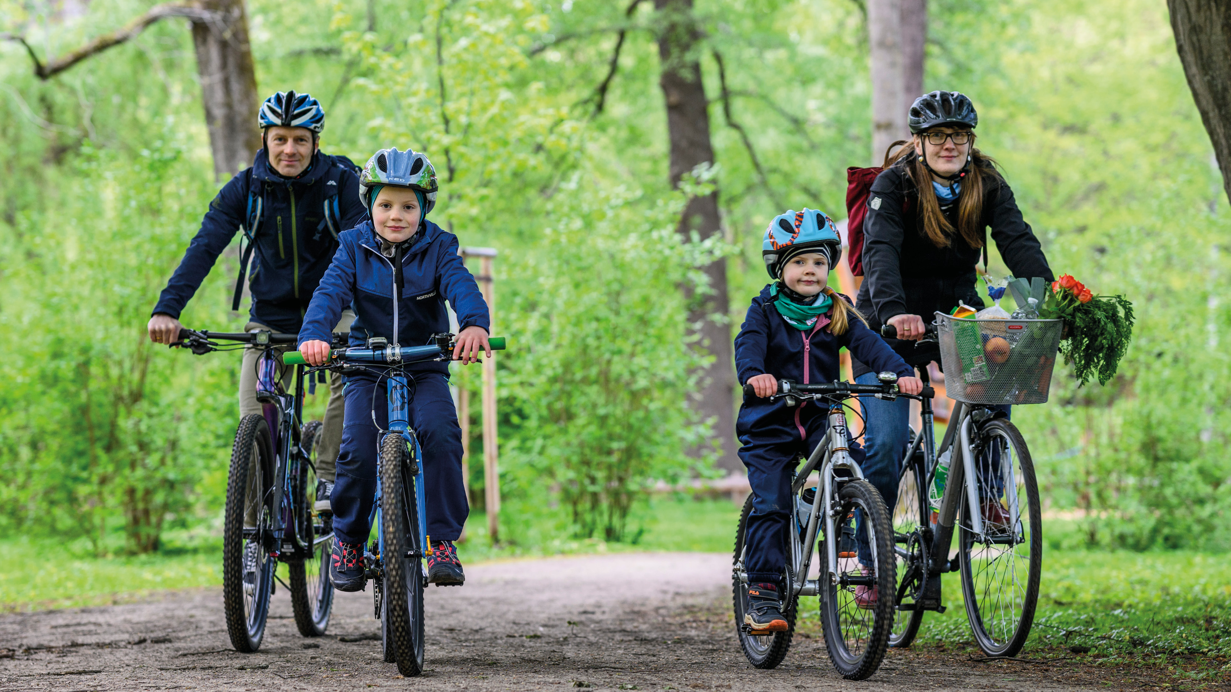 Radfahrende Familie im Schloßteichpark