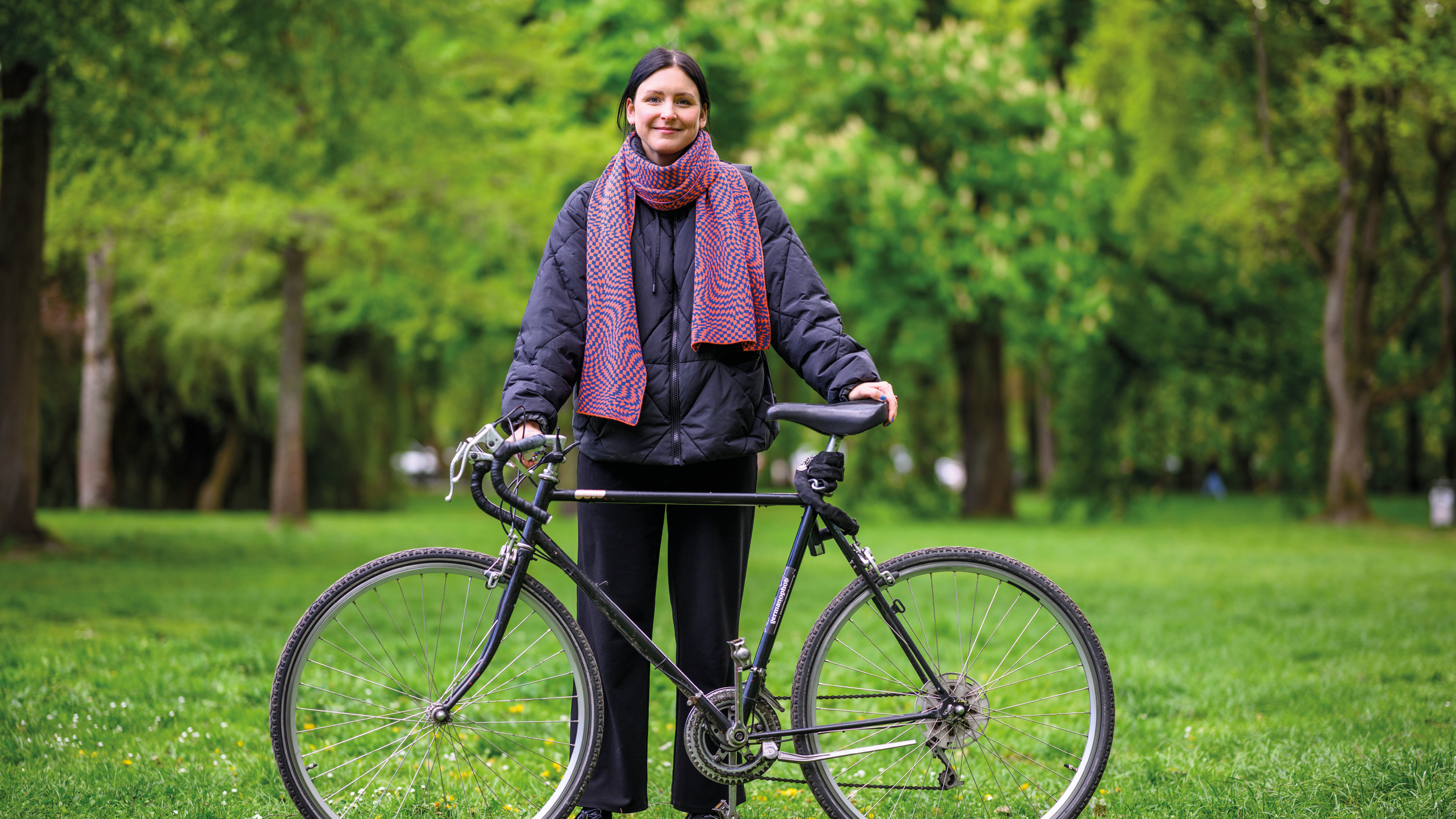 Anne mit ihrem Fahrrad auf einer grünen Wiese